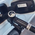 a close up of a gas pump with a car in the background